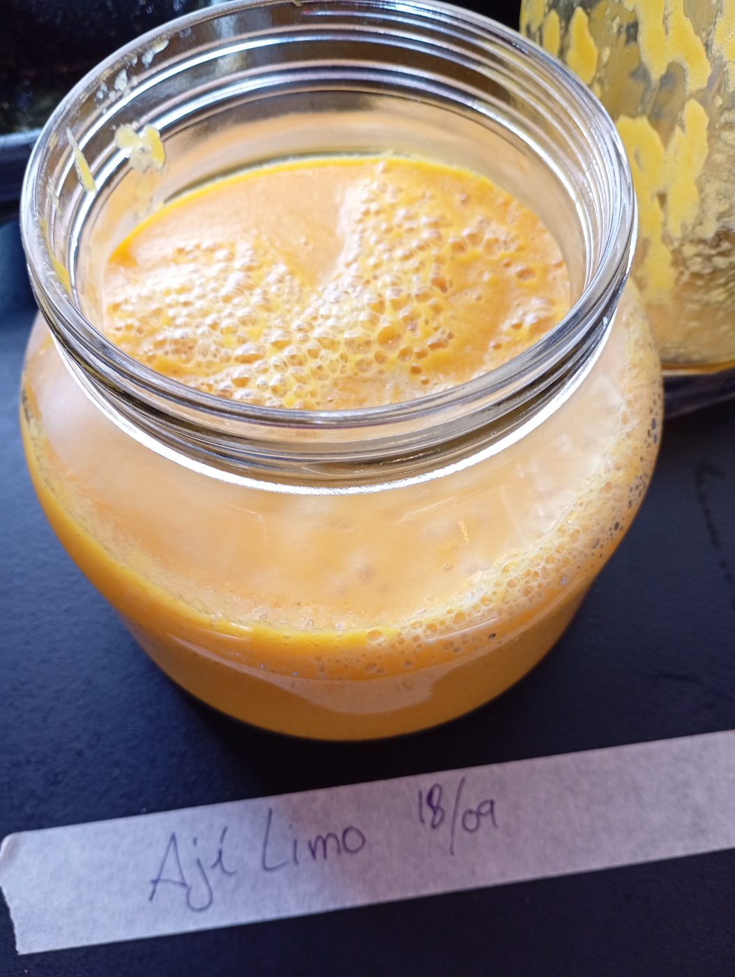 Bote de cristal con salsa ají limo terminada, etiquetado a mano con la fecha 18/09