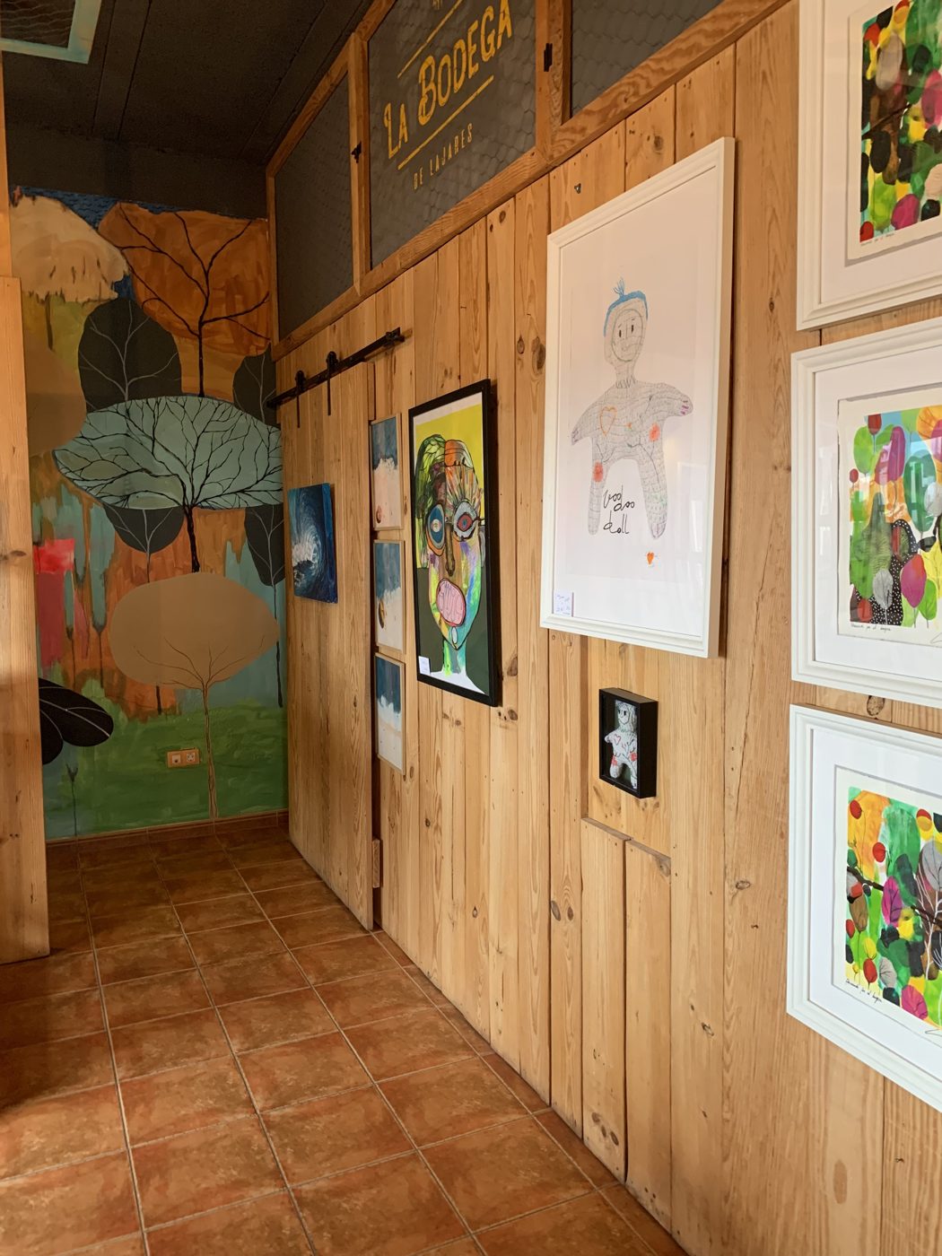 Pared de madera con cuadros y murales de colores en el interior de La Central